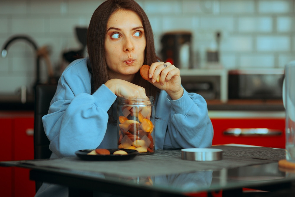 femme qui mange des biscuits en secret