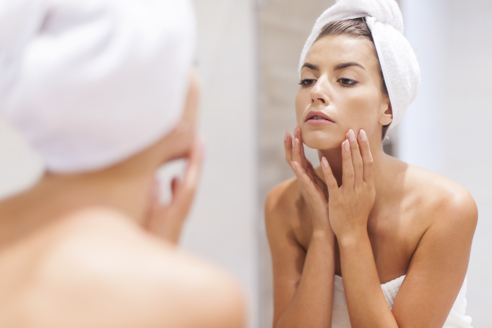 femme regarde visage dans le miroir