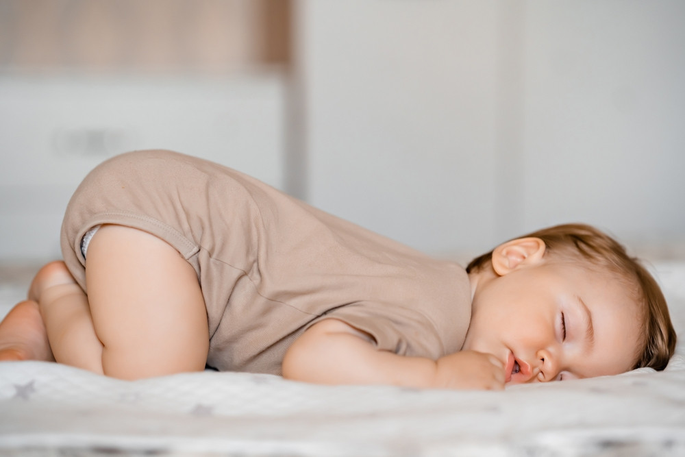 Mon bébé dort les fesses en l’air : qu’est-ce que ça signifie ?