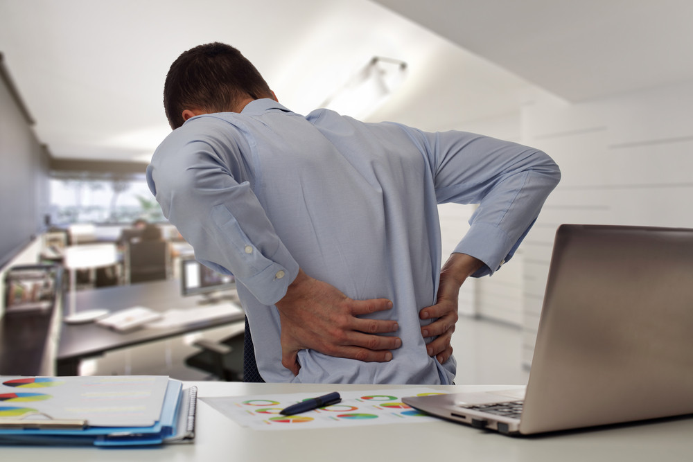 homme au bureau avec mal au dos