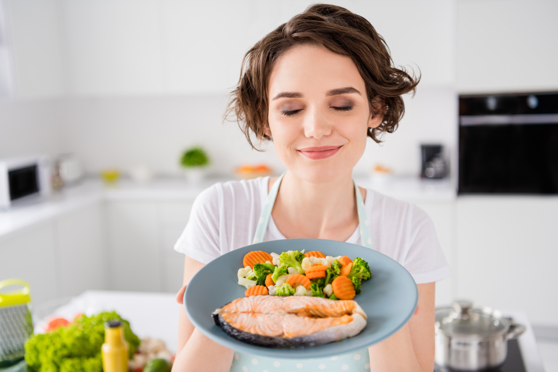 femme avec assiette de saumon et légumes
