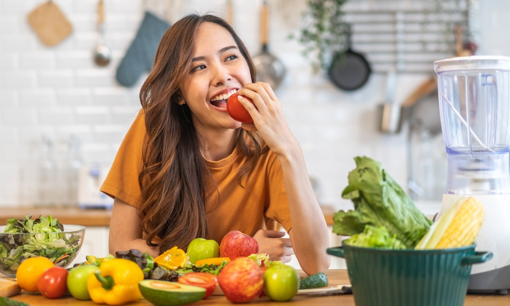 Femme qui mange des fruits et des légumes