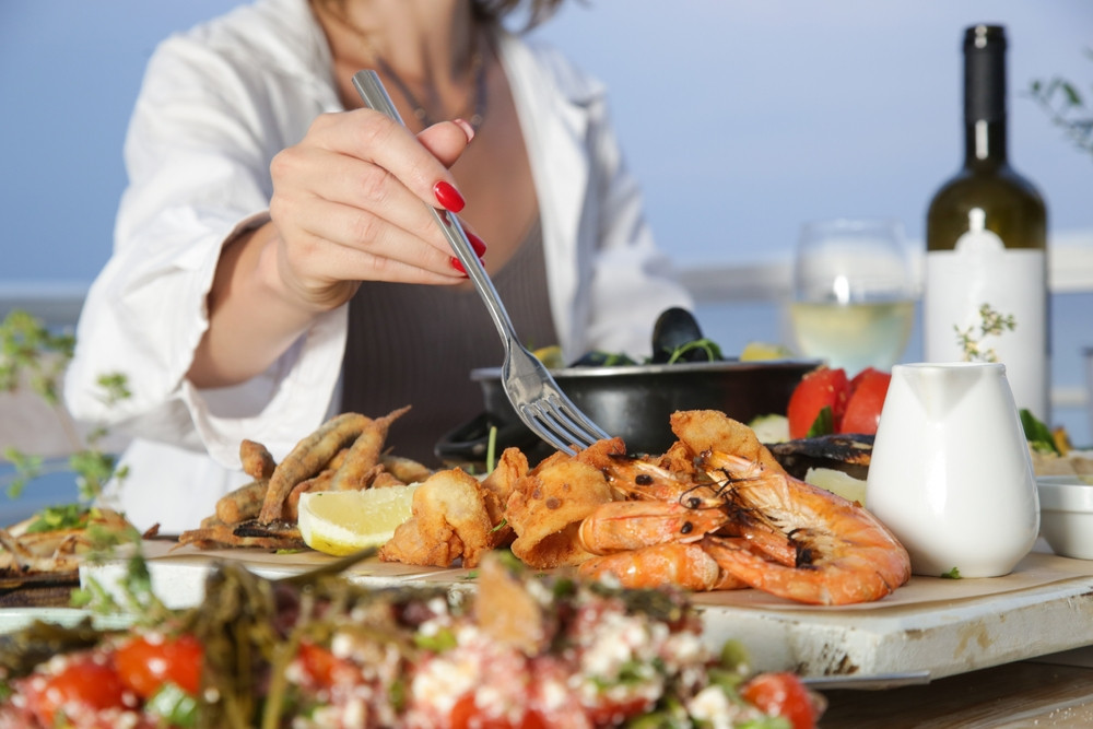 personne qui mange plateau fruits de mer