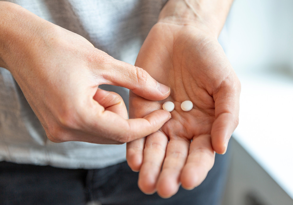 personne avec médicament dans la main