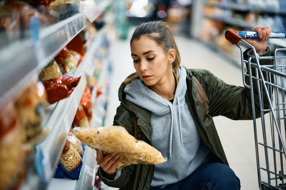 femme qui choisit des pâtes au supermarché 
