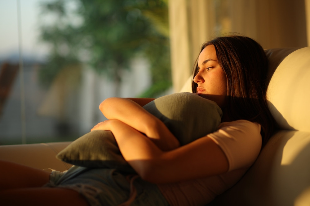 femme triste au coucher du soleil