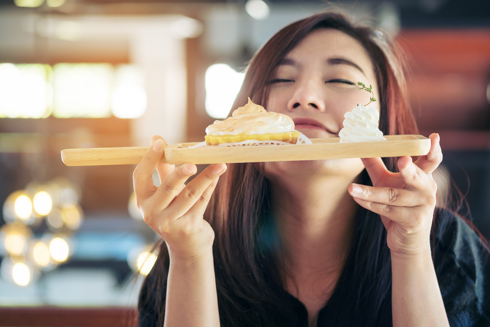 Femme qui respire l'odeur d'un bon gateau