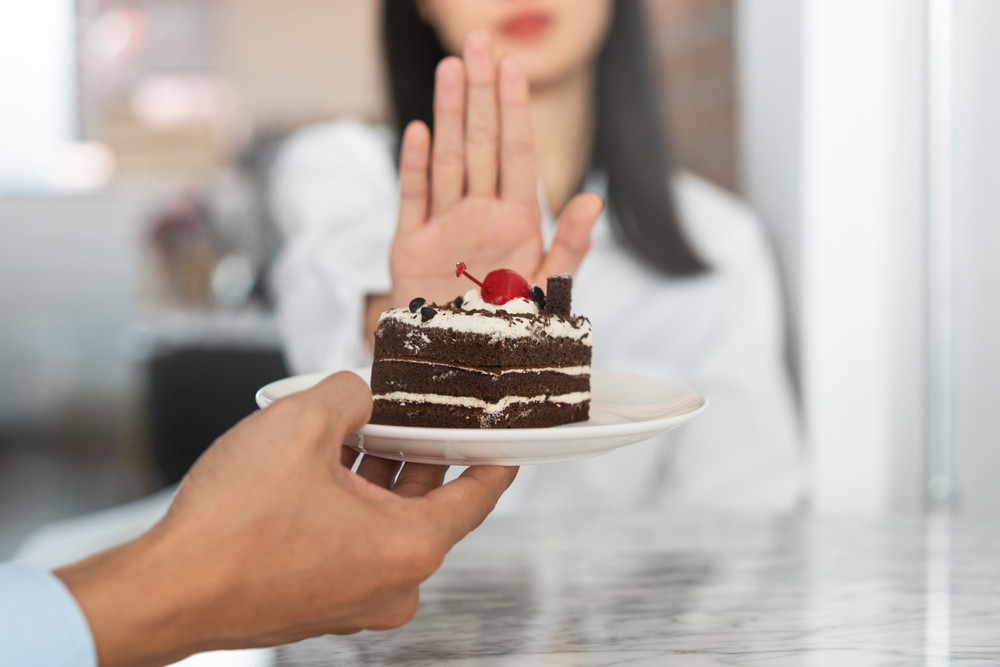 femme qui refuse un part de gâteau