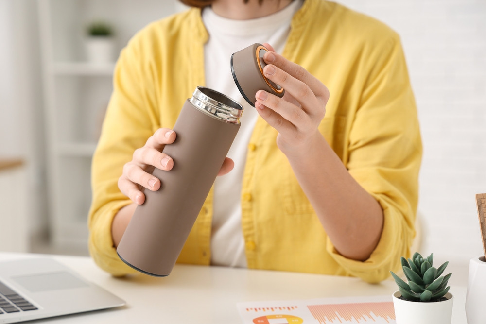 femme qui ouvre thermos
