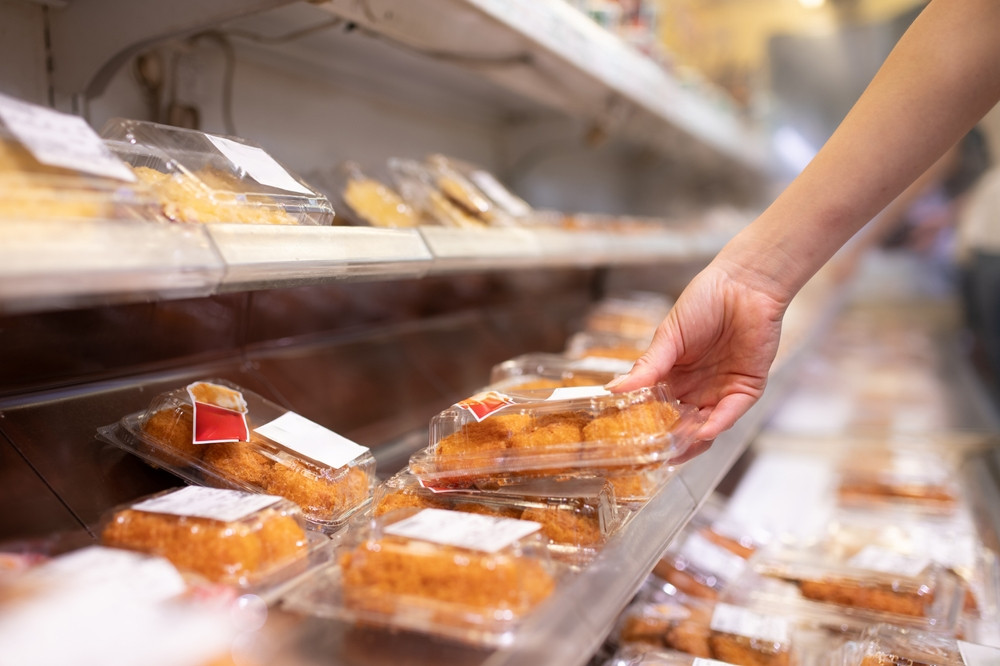 personne qui choisit pâtisserie au supermarché