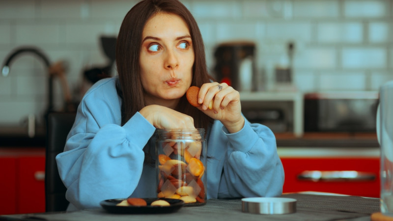 femme qui mange des biscuits en secret