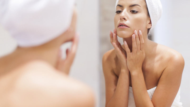 femme regarde visage dans le miroir