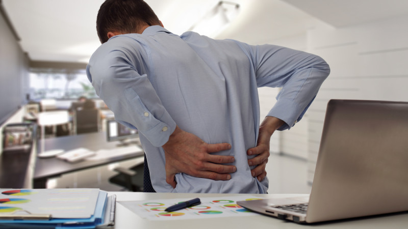homme au bureau avec mal au dos