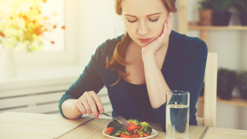 femme triste devant petite assiette