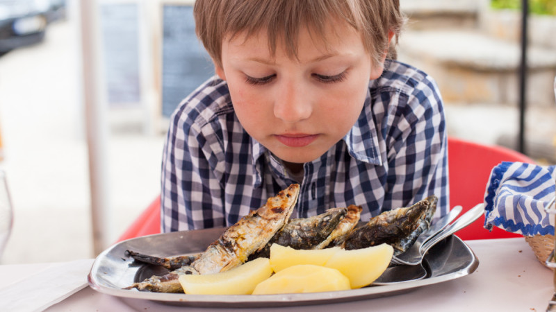 enfant qui mange des sardines