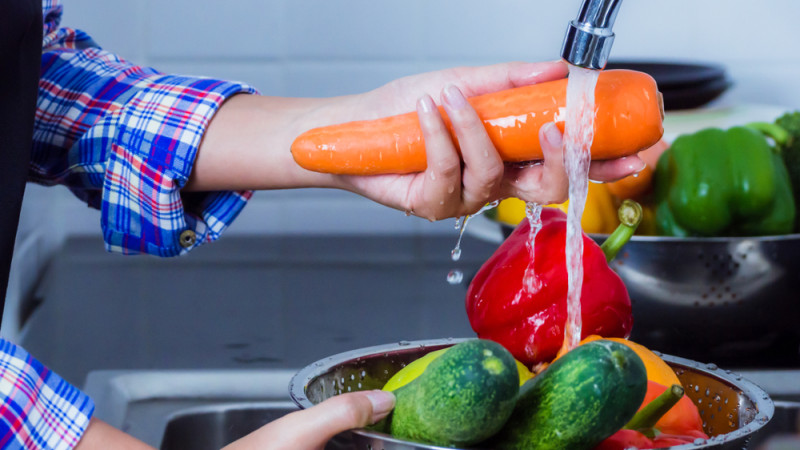 personne qui lave des légumes