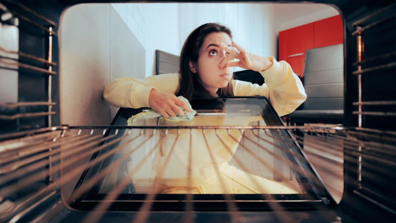 femme nettoie four qui sent mauvais