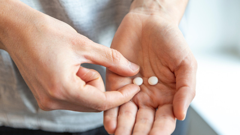 personne avec médicament dans la main