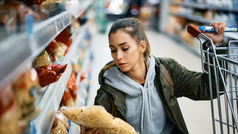 femme qui choisit des pâtes au supermarché 