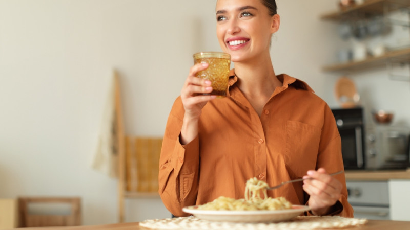 femme boit de l'eau en mangeant 