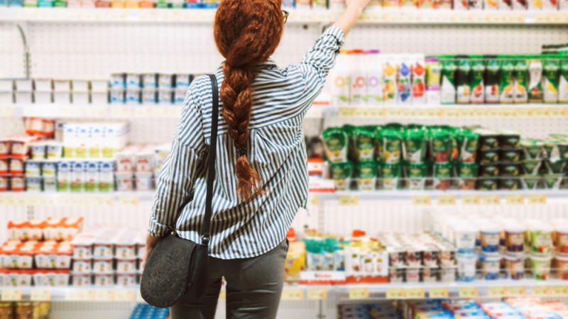 femme qui choisit des yaourts au supermarché