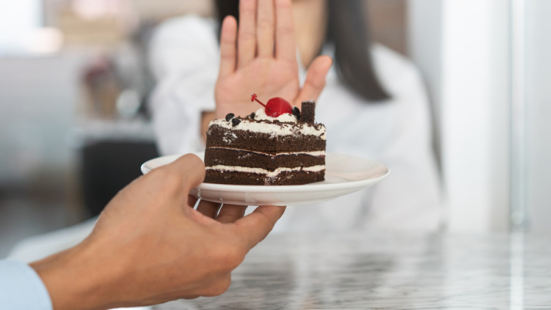 femme qui refuse un part de gâteau