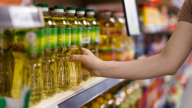 personne choisit huile au supermarché
