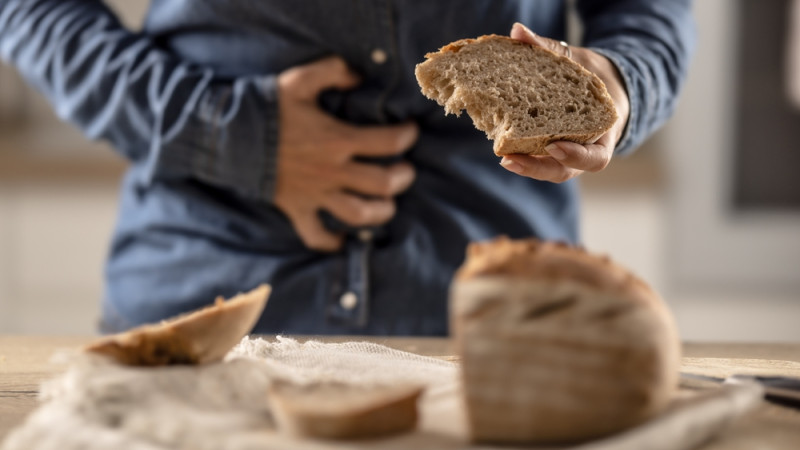 personne avec mal de ventre en mangeant du pain