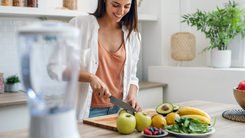 Femme qui prépare à manger avec des fruits et des légumes