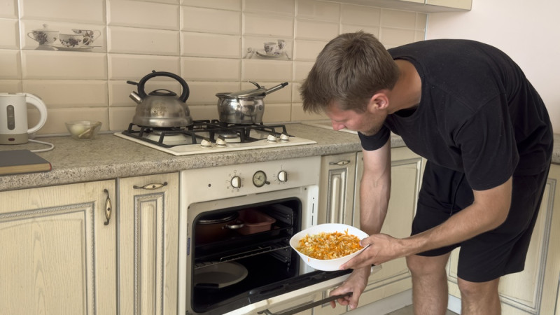 homme sort un plat du four
