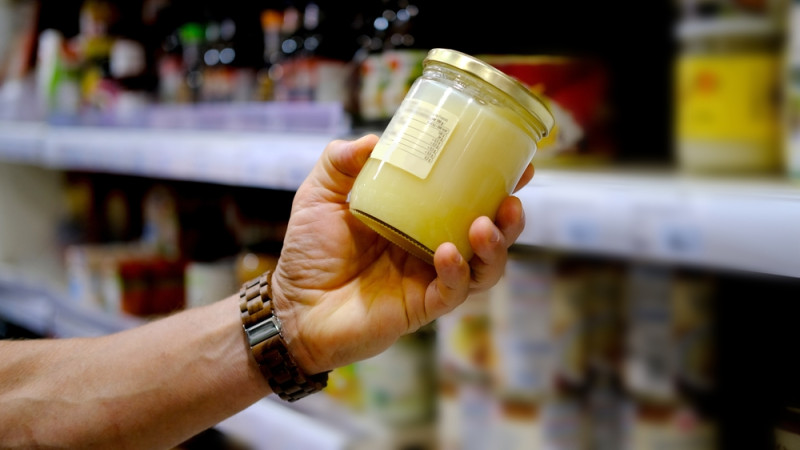 personne choisit miel au supermarché