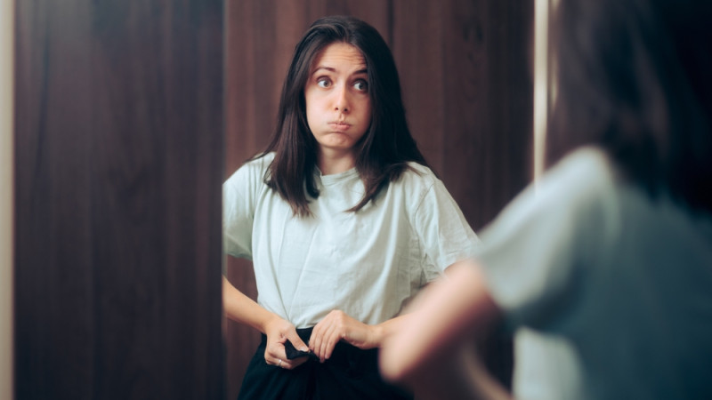 femme qui ferme pantalon trop serré 