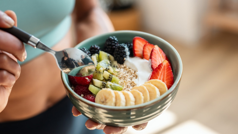 femme qui mange une salade de fruits