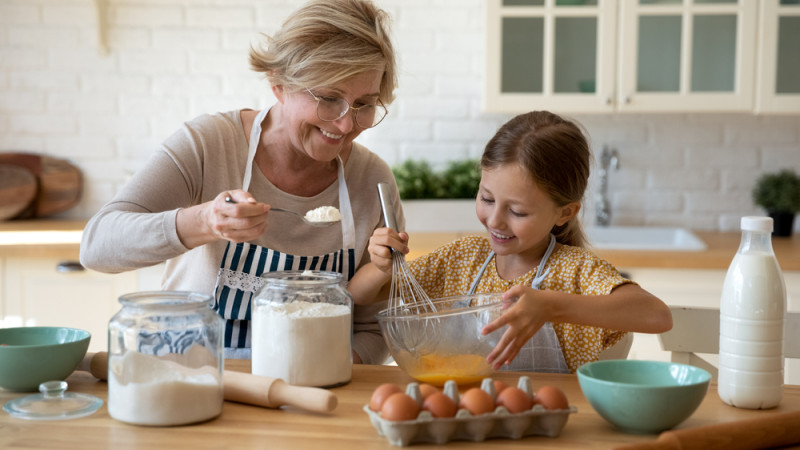 grand-mère  qui prépare un gâteau avec sa petite fille