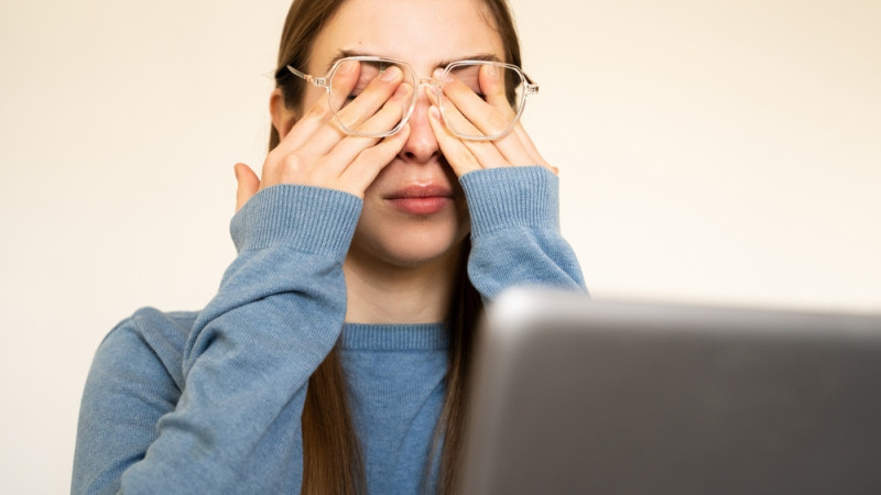 femme avec les yeux irrités devant un écran