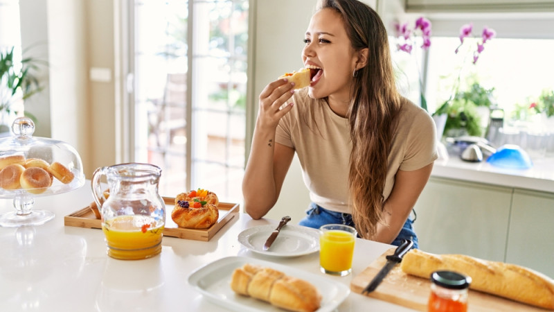 femme qui mange du pain au petit-déjeuner 