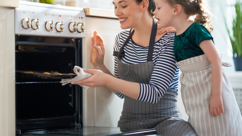 maman sort des gâteaux du four avec sa fille