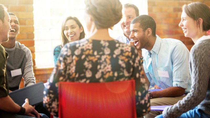 personnes qui rient en séance de thérapie de groupe
