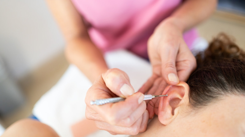 personne qui pratique de l'auriculothérapie