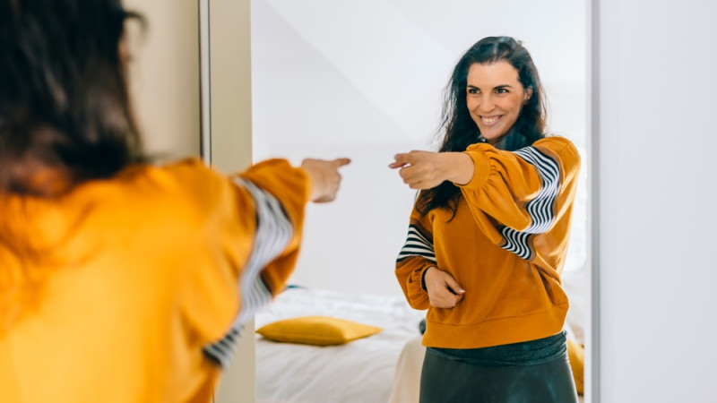 femme se pointant du doigt devant le miroir