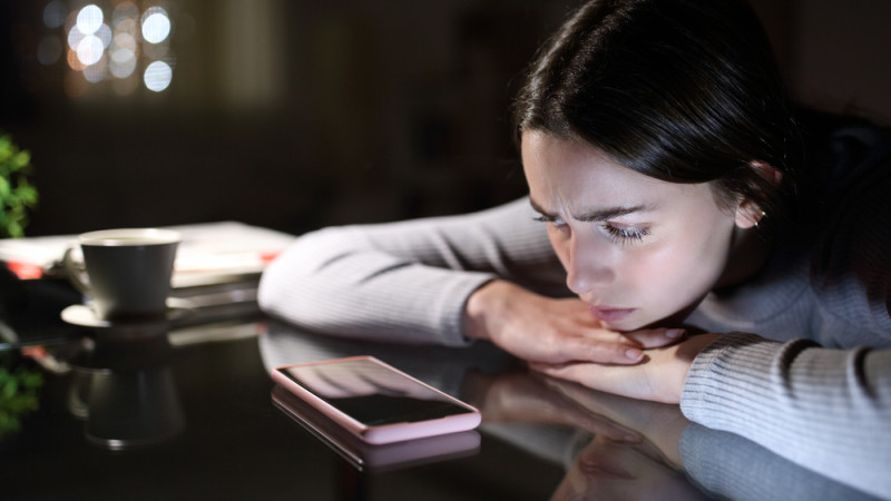 femme triste devant son téléphone