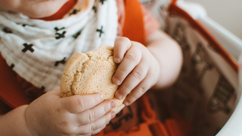 bébé qui mange un biscuit