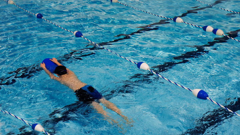 personne nage avec planche de natation