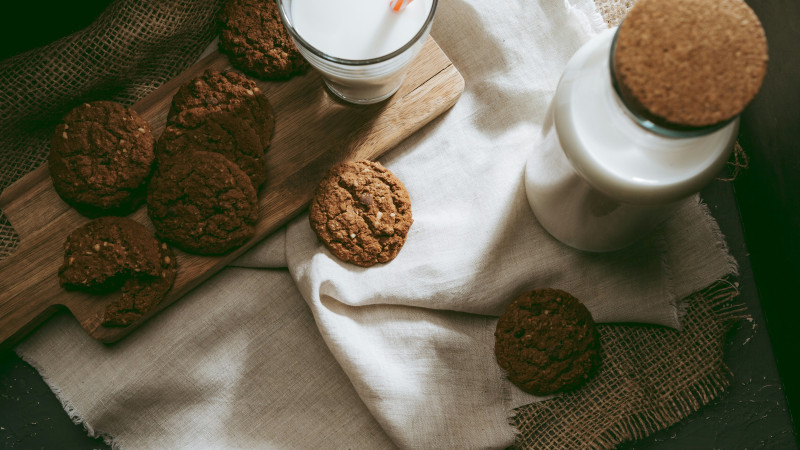 a group of brown round objects on a white cloth next to a white cup and a white sauce