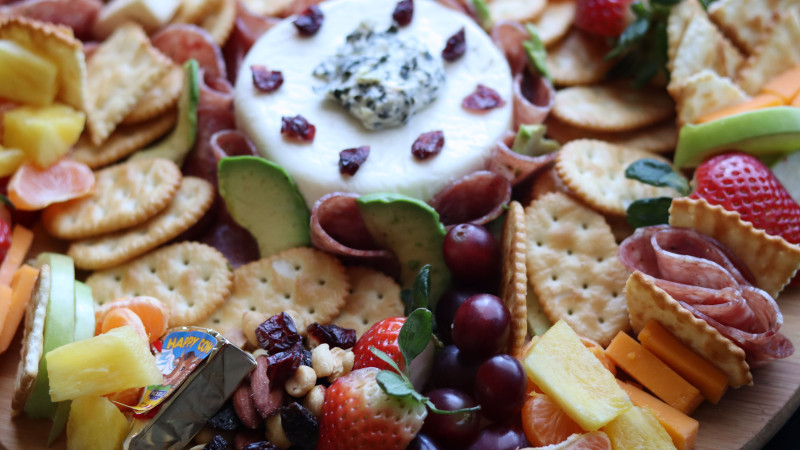 Plateau de fromage artisanal délicieux avec une variété de fruits frais, parfait pour recevoir.