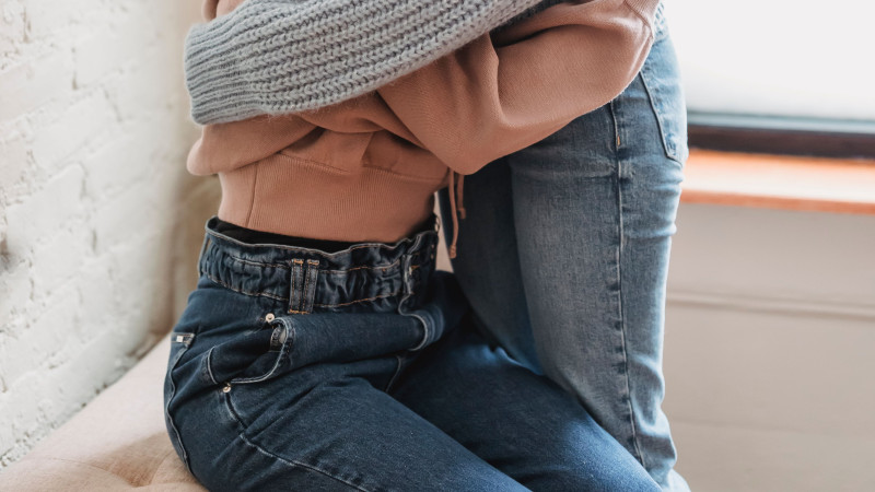 Deux femmes s'enlacent chaleureusement, offrant un soutien émotionnel dans un cadre intérieur.