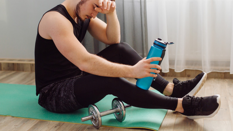 Jeune homme faisant des exercices de sport à la maison