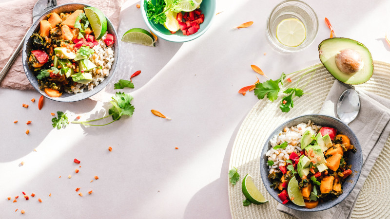 Vue de dessus de bols végétaliens colorés remplis de légumes frais, parfaits pour un repas sain.
