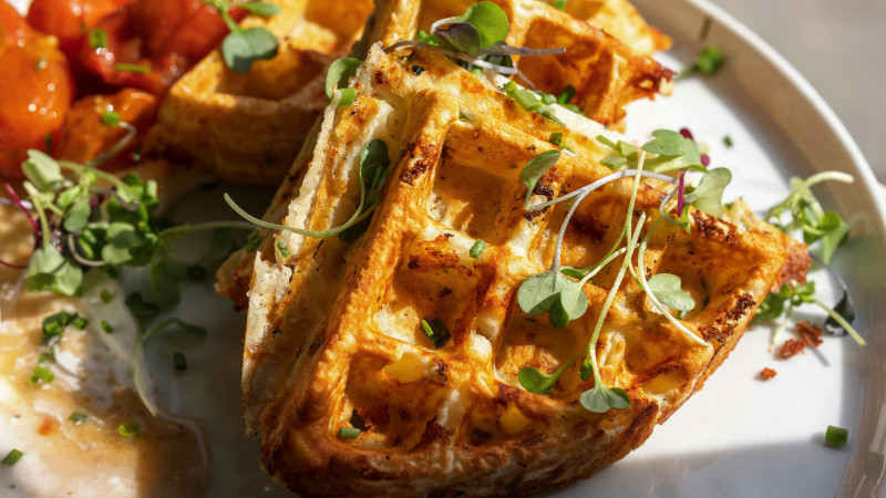 a plate of waffles and vegetables on a table
