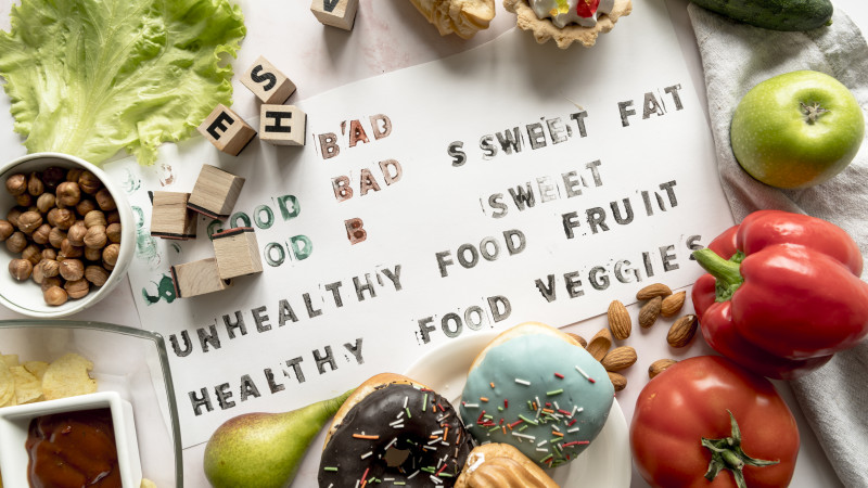 Texte sain et malsain sur papier entouré d'aliments frais